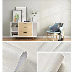 Parede revestida com papel de parede adesivo em tons de cinza e dourado.