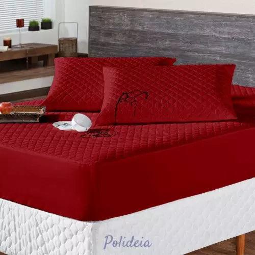 protetor de colchão impermeável matelado vermelho sobre uma cama de casal