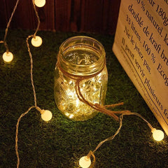 Um jardim florido com um caminho iluminado por um varal de luzes LED cordão