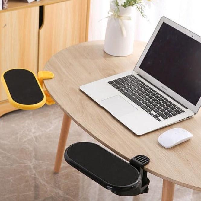  apoio de antebraço ergonômico para mesa preto, fixado na borda de uma mesa de madeira, com um notebook e um mouse sobre a mesa.