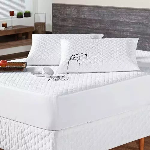  protetor de colchão impermeável matelado branco sobre uma cama de casal