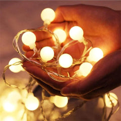 Um jardim florido com um caminho iluminado por um varal de luzes LED cordão